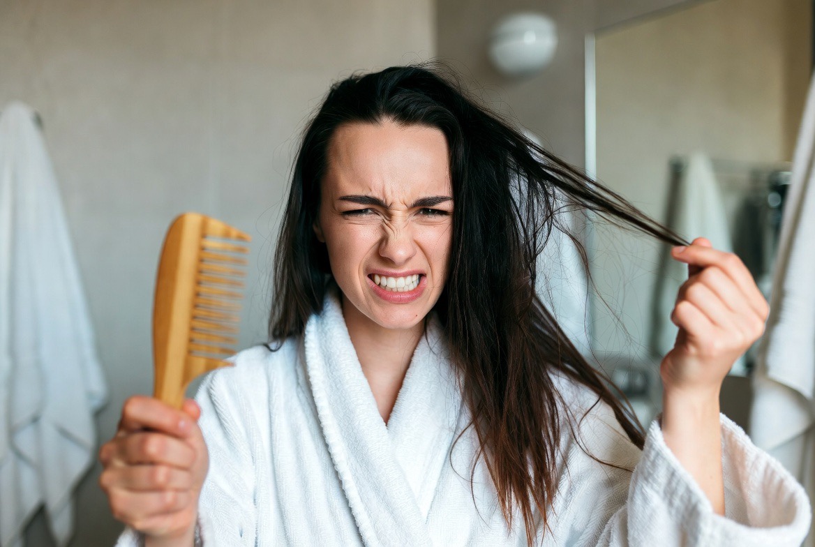 Woman struggling with dry tangled hair